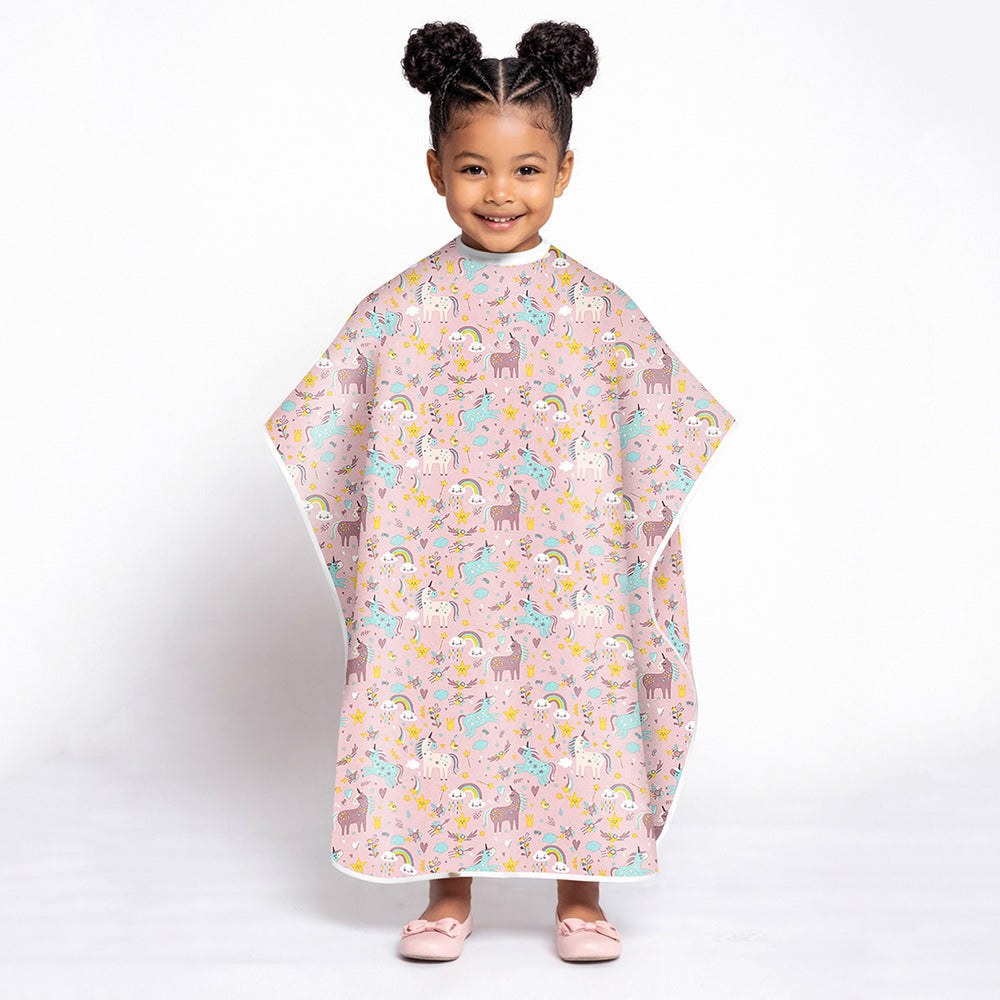 Child wearing a colorful unicorn pink animal-patterned poncho on a white background