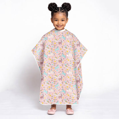 Child wearing a colorful unicorn pink animal-patterned poncho on a white background