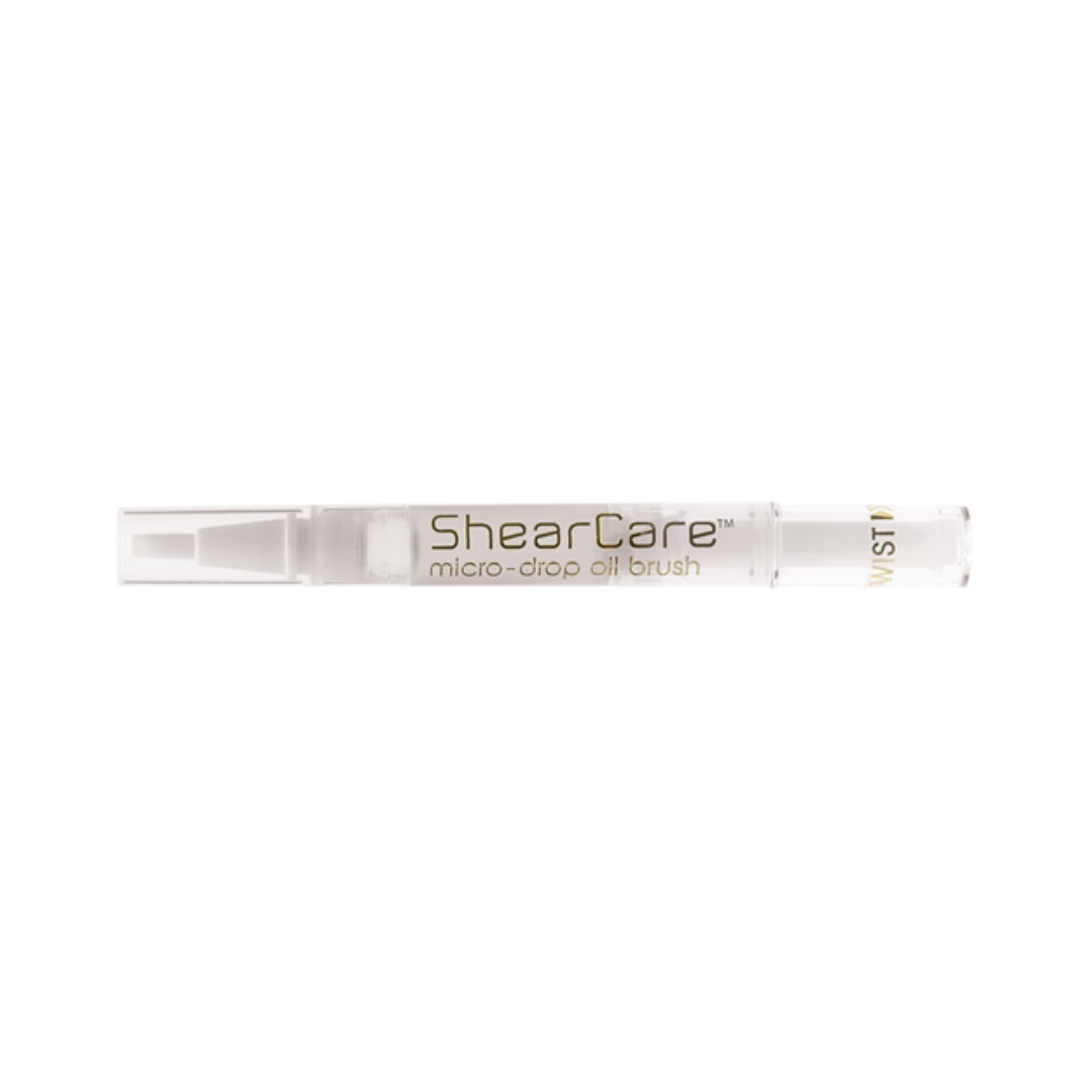 ShearCare micro-drop oil brush in a clear cylindrical container with gold lettering, shown horizontally against a plain white background.