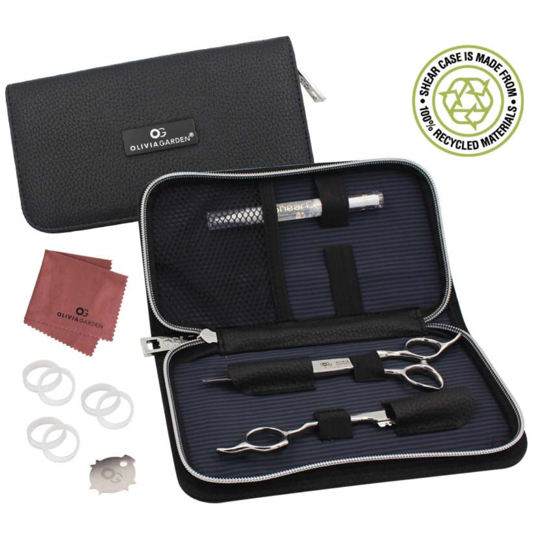 Olivia Garden scissor case kit shown open on a white background, with a black zippered carrying case, metal hair scissor and thinner, white finger hole rings, shear oil and a red cleaning cloth. A circular badge in the top right says the case is made from