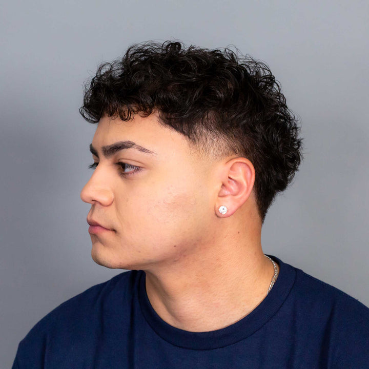 Person wearing a navy blue shirt against a gray background